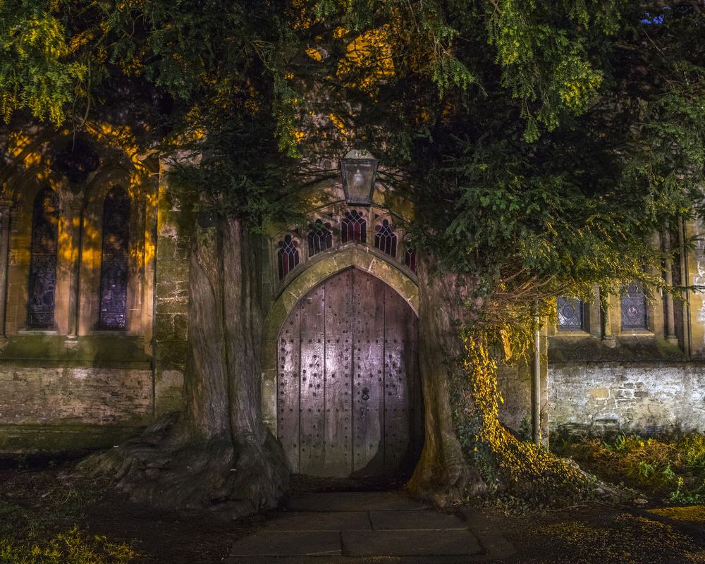 Stow on the wold England. Door among trees Evening View of St. Edwards Church in Stow-on-the-Wold, UK
