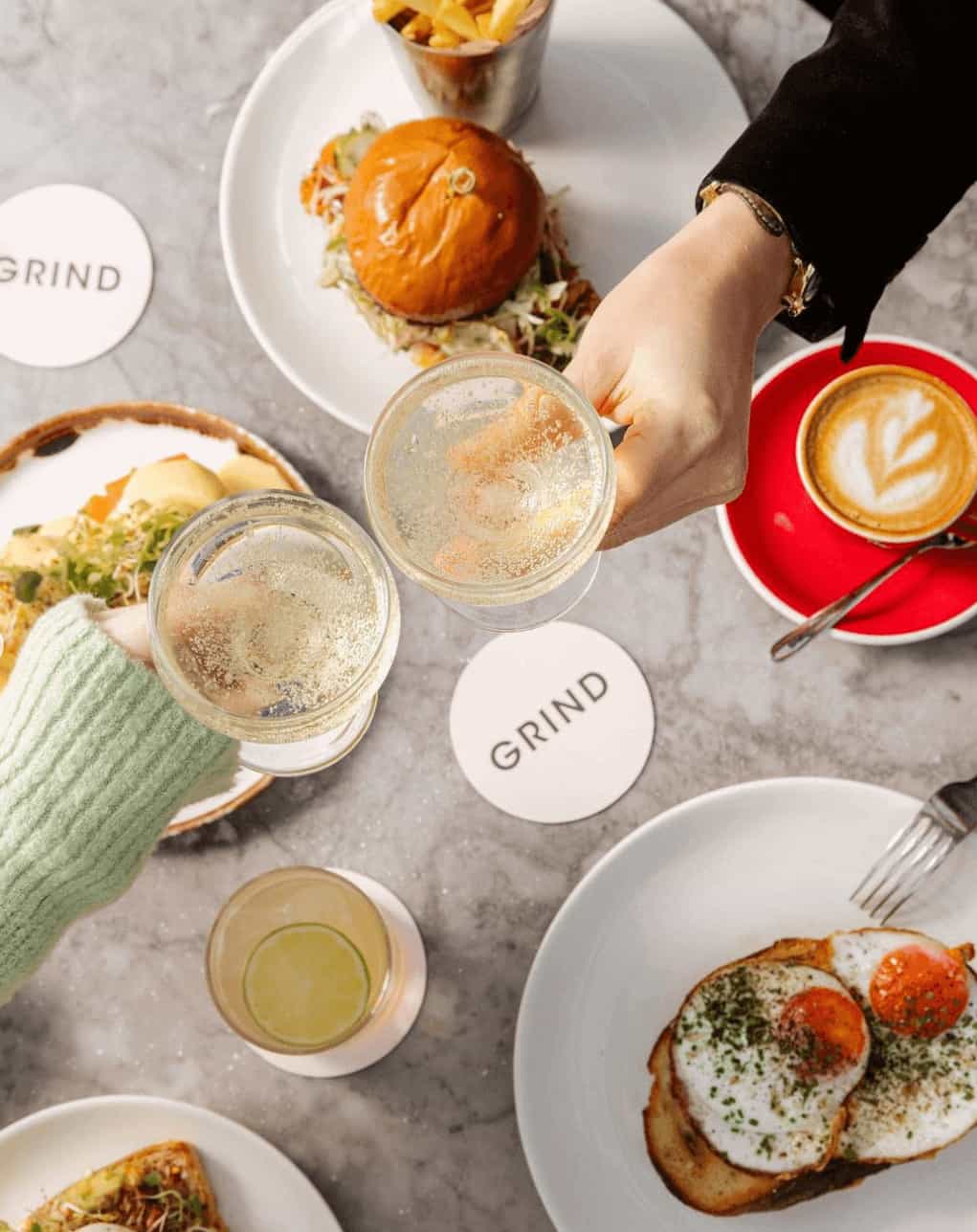 Covent Garden Grind, tow people sharing a glass of wine over brunch in London