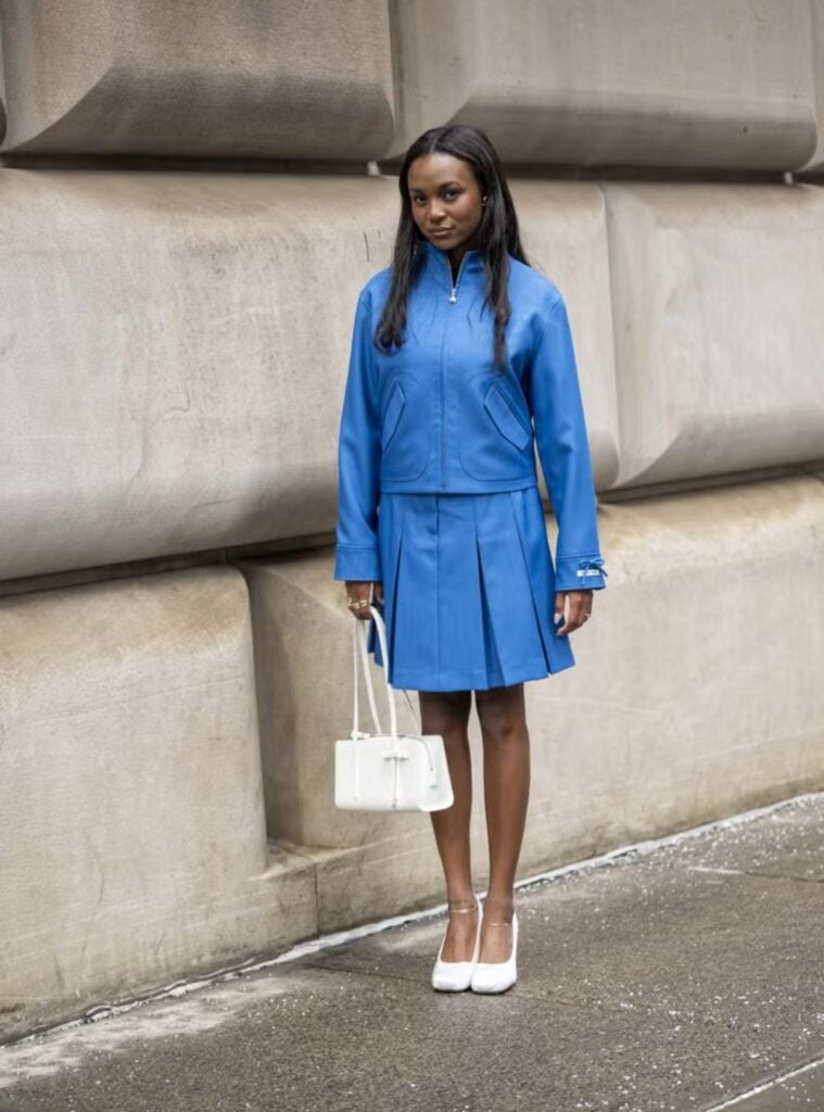 blue zip-up jacket + pleated mini skirt + white heels