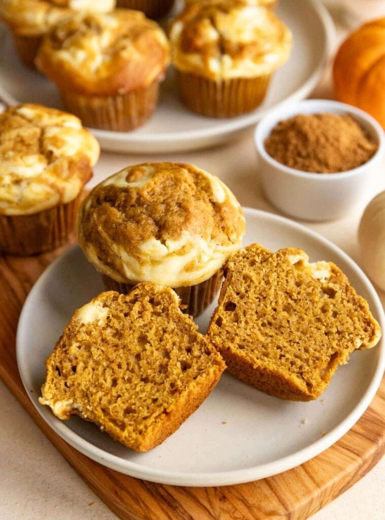 pumpkin muffins with cream cheese swirled centers on a cooling rack