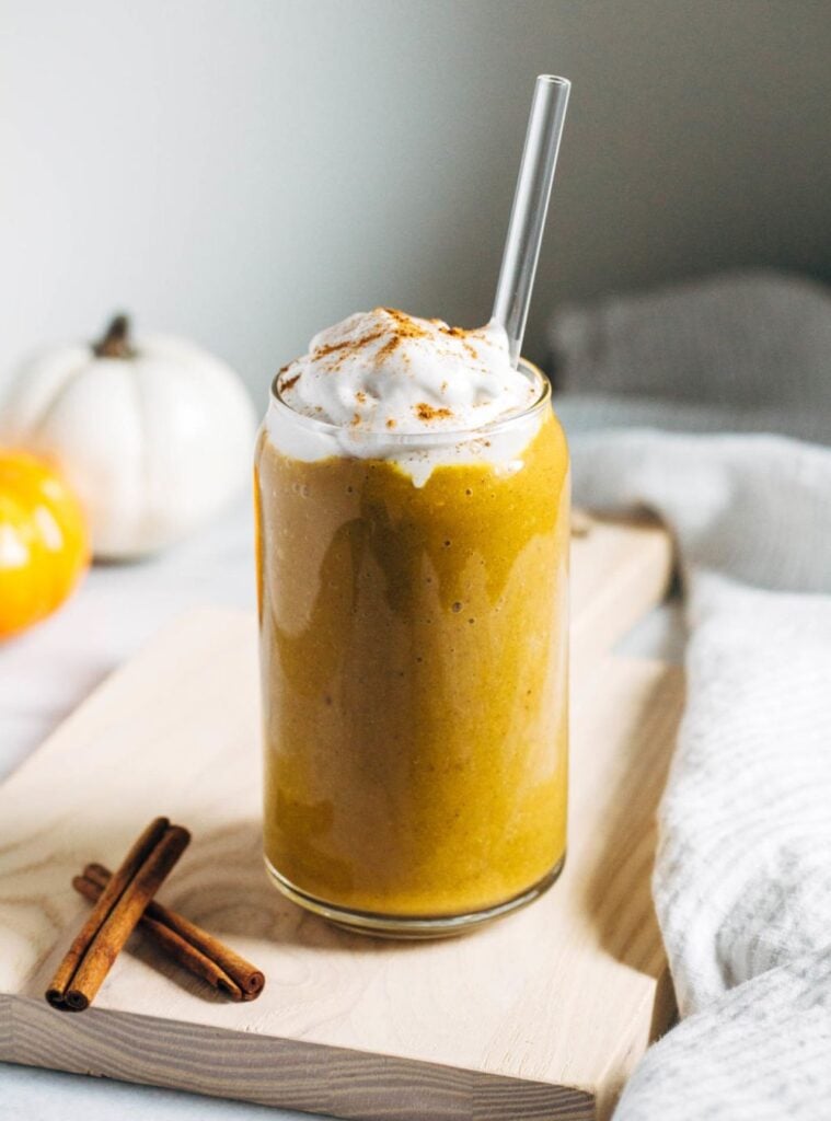 glass of pumpkin smoothie with straw, refreshing and spiced, made for quick mornings