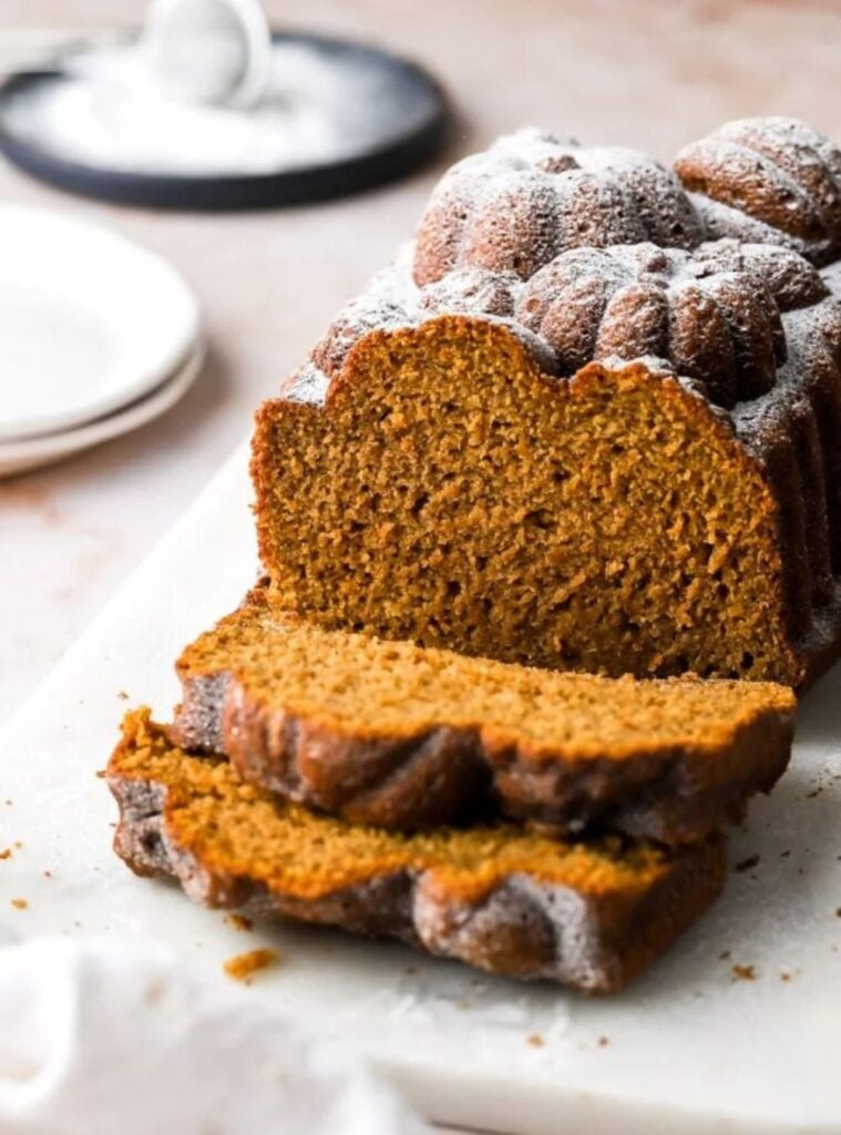 loaf of banana pumpkin bread sliced on a wooden board, great for weekend fall cooking