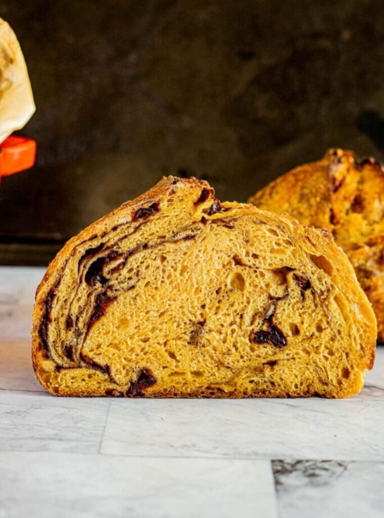 rustic loaf of pumpkin sourdough bread sliced on a cutting board, wholesome healthy pumpkin recipes option