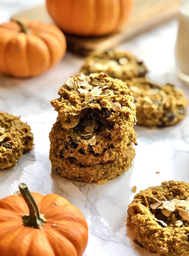 pumpkin breakfast cookies stacked on parchment paper, soft and chewy snack