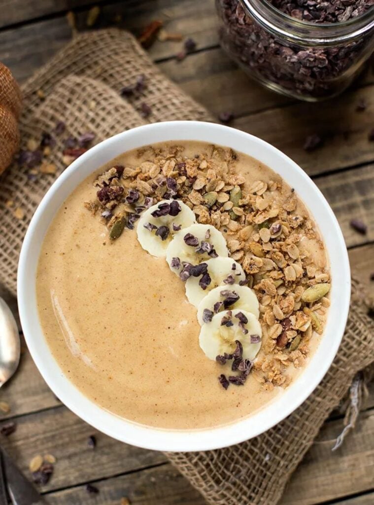 pumpkin smoothie bowl topped with seeds and granola, colorful easy pumpkin recipe