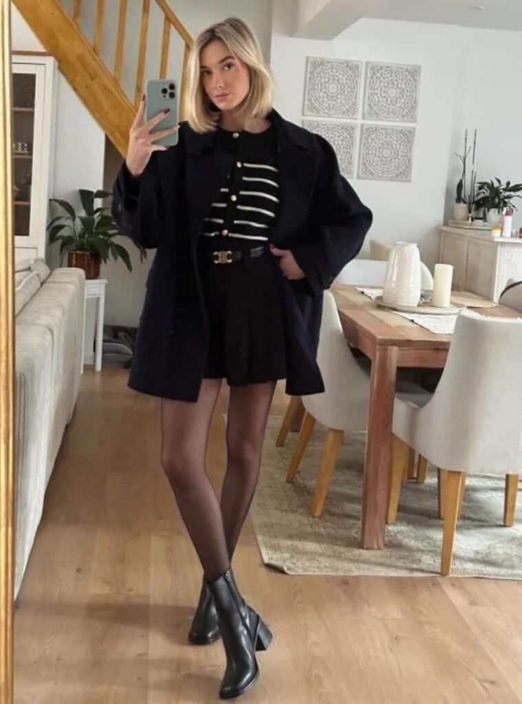 1 Navy Coat Striped Cardigan Black Pleated Mini Skirt Black Tights Black Ankle Boots office christmas party outfit for women navy coat mini skirt