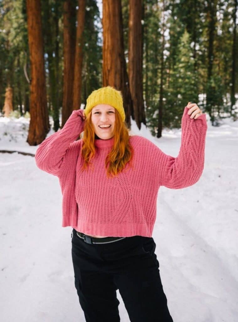 1 Yellow Beanie Pink Chunky Knit Sweater Black Cargo Pants yellow beanie styled with a pink chunky knit sweater and black cargo pants a bright and cozy winter hiking outfit with a playful color mix