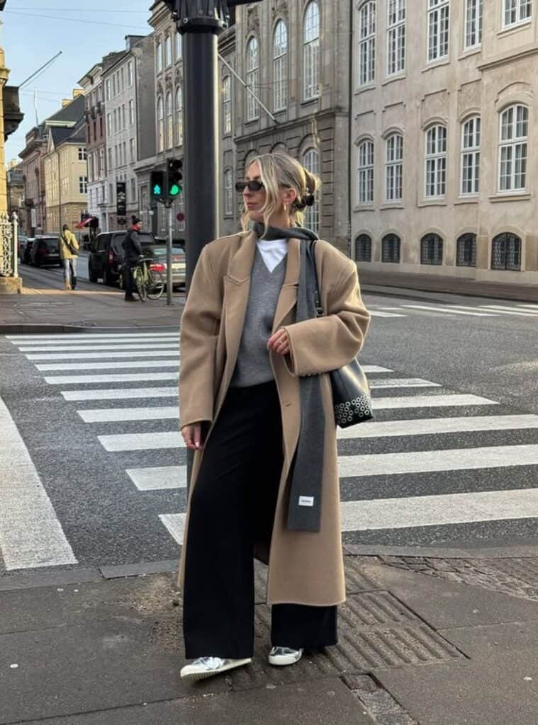10 Caramel Longline Coat Black Wide Leg Trousers Metallic Sneakers modern winter looks for spain featuring a caramel longline coat styled with black wide-leg trousers and metallic sneakers