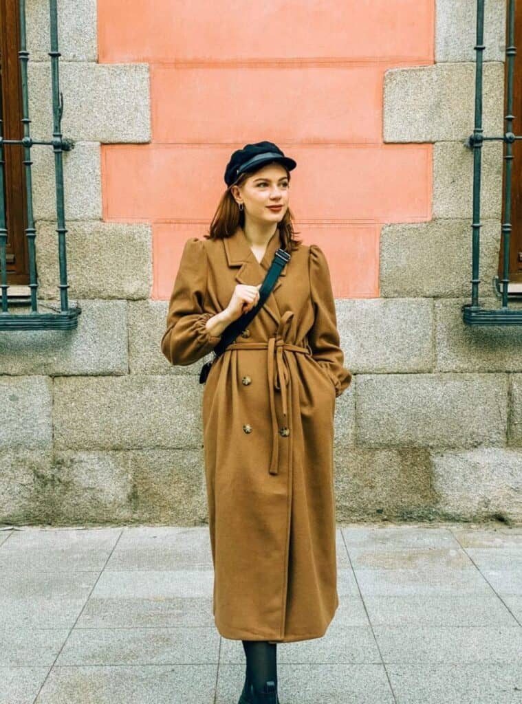 11 Tan Puff Sleeve Trench Coat Black Newsboy Cap Black Ankle Boots travel-ready winter outfits in spain styled with a tan puff-sleeve trench coat, black newsboy cap, and black ankle boots