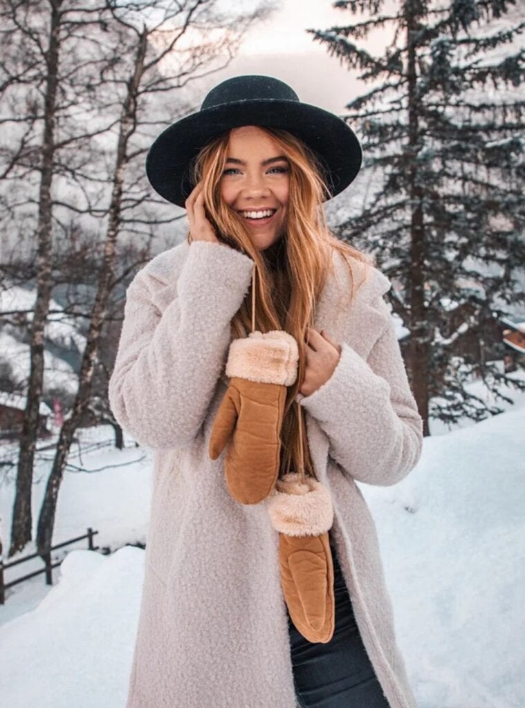 17 Cream Teddy Coat Black Turtleneck Black Denim Jeans Matching Fedora cream teddy coat layered over a black turtleneck and denim jeans for switzerland winter outfits in snow