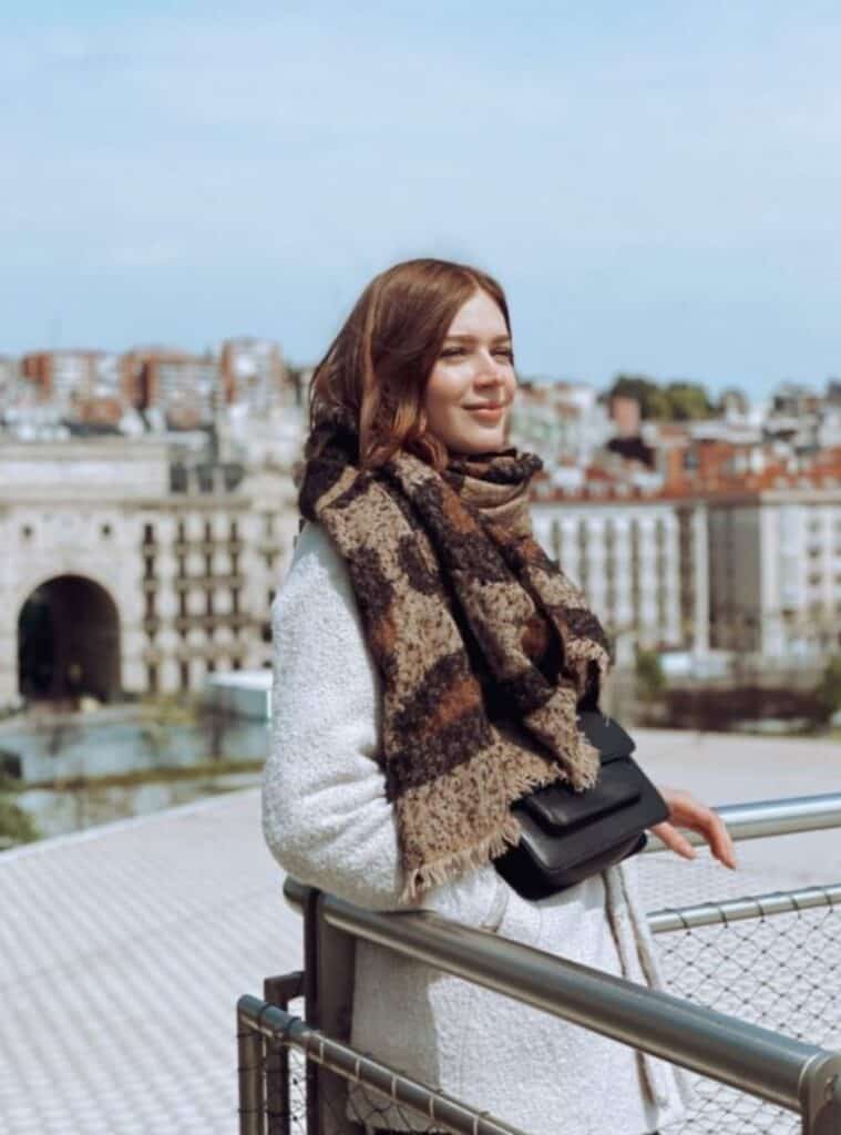 18 Leopard Print Scarf White Boucle Coat Black Leather Bag classic winter travel outfits featuring a white bouclé coat styled with a leopard print scarf and black leather bag