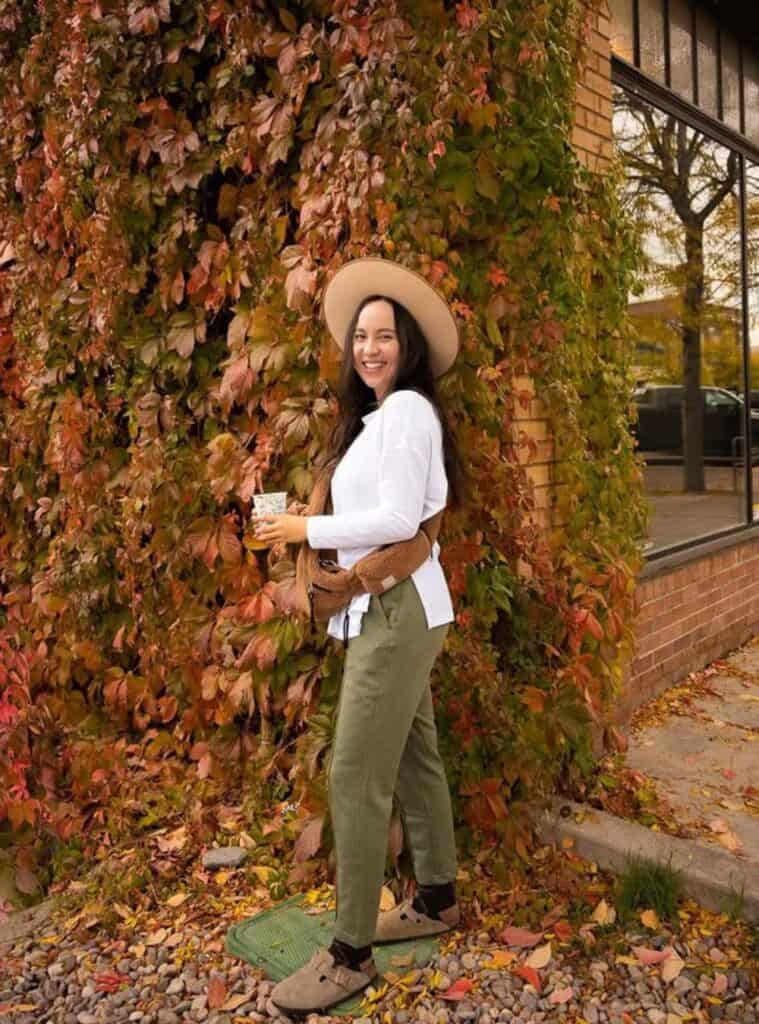 23 White Split Hem Top Olive Tapered Trousers Taupe Suede Clogs white split hem top styled with olive tapered trousers and taupe suede clogs a relaxed hiking in winter outfit with earthy colors