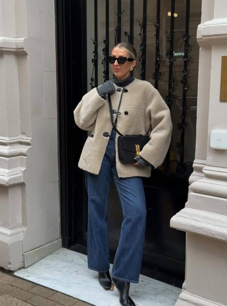 26 Shearling Toggle Coat Straight Leg Jeans Black Leather Boots cozy winter outfits in spain featuring a shearling toggle coat styled with straight-leg jeans and black leather boots