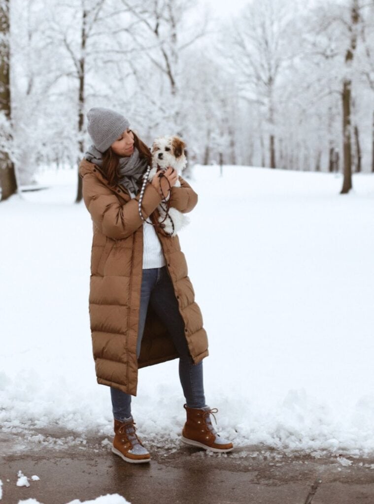31 Camel Longline Puffer White Cable Knit Sweater Dark Wash Skinny Jeans camel longline puffer layered over a white cable knit sweater with dark wash skinny jeans a classic winter hiking outfit for women