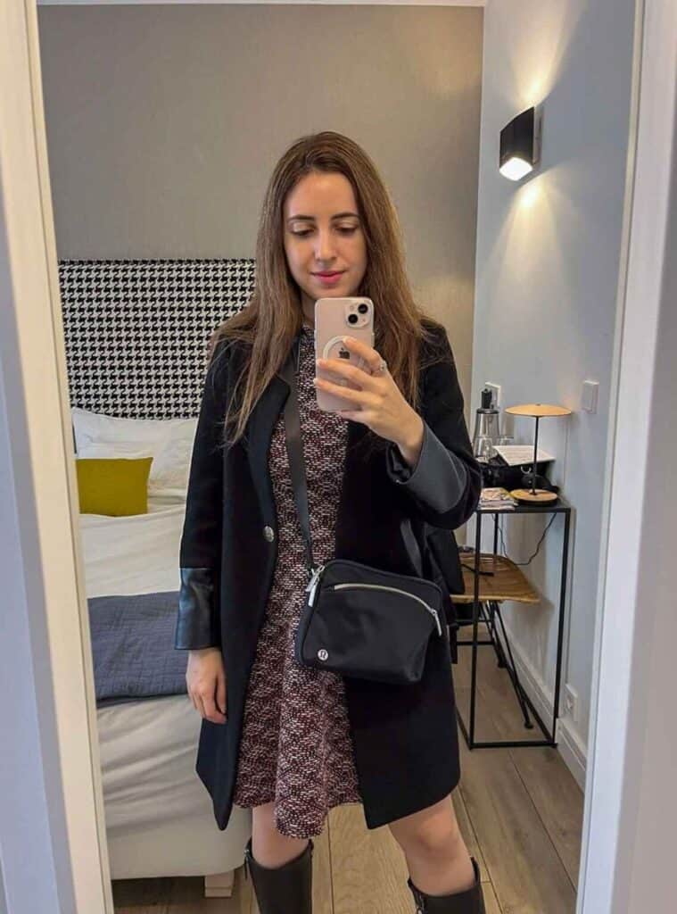 4 Black Coat with Leather Cuffs Patterned Mini Dress Black Crossbody Bag stylish winter outfits for spain featuring a black coat with leather cuffs, patterned mini dress, and black crossbody bag