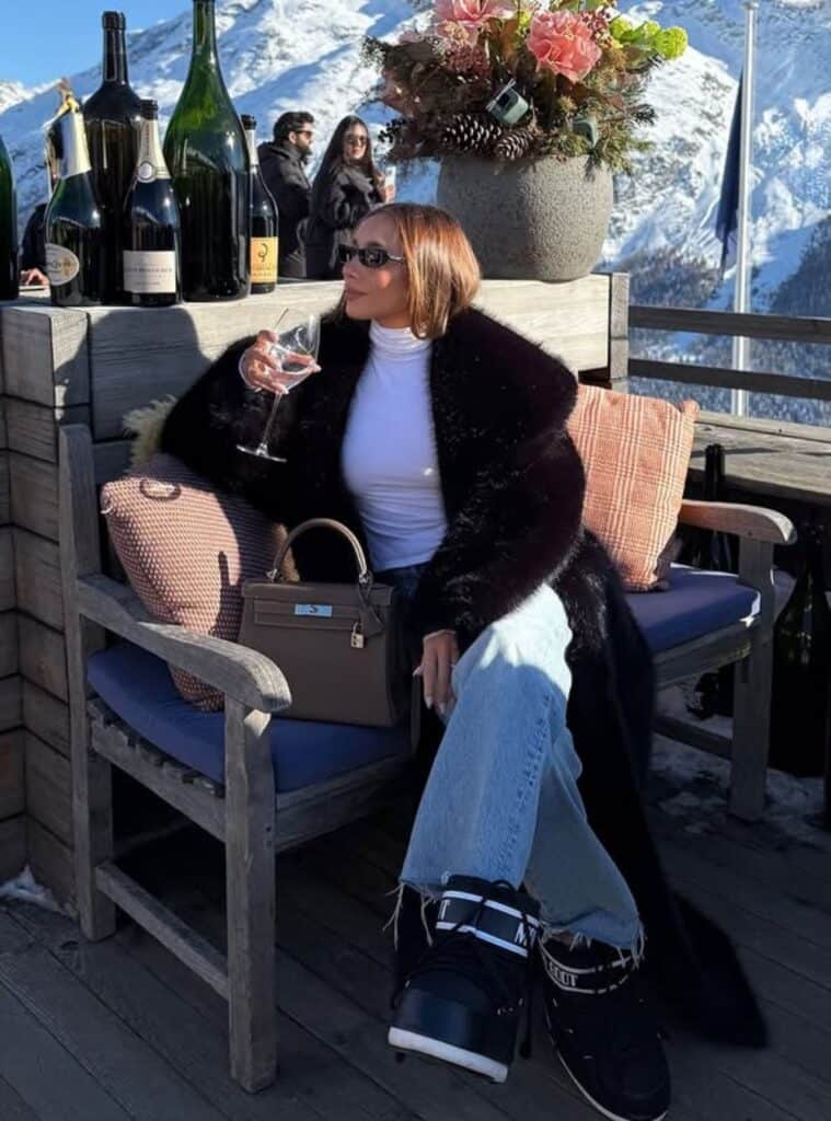 9 Long Black Fur Coat White Turtleneck Moon Boots long black fur coat paired with a white turtleneck and moon boots for switzerland winter outfits in snow